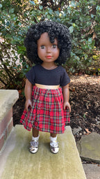 A Dark Brown Skin Tone Doll in a Black & Red Holiday Dress